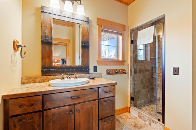 bathroom featuring a shower stall, vanity, and baseboards