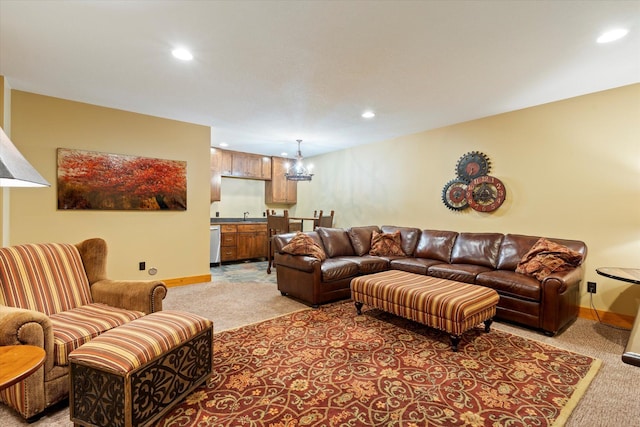 living room featuring light carpet, recessed lighting, baseboards, and bar with sink