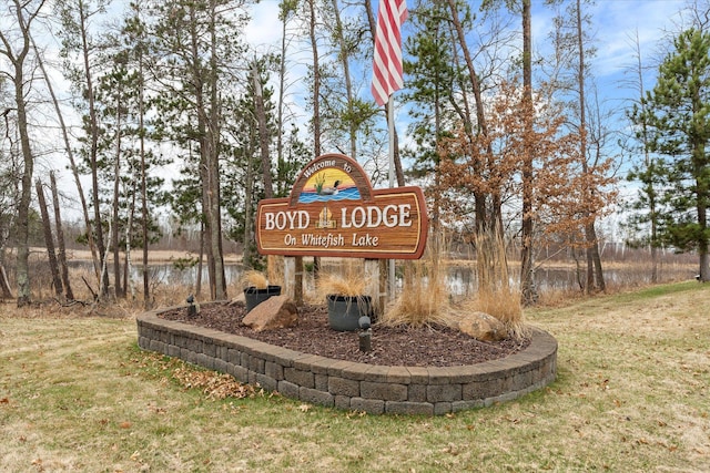 community / neighborhood sign featuring a yard