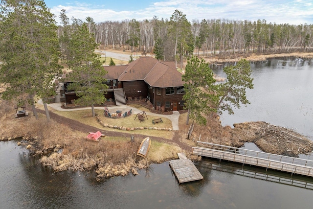 view of subject property with a nearby body of water and a heavily wooded area