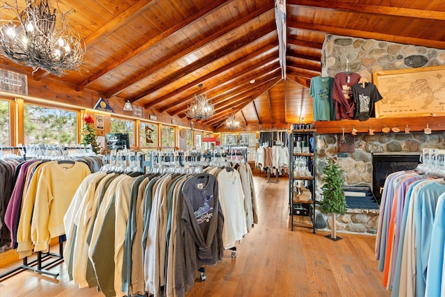 walk in closet with a chandelier, hardwood / wood-style floors, and a stone fireplace