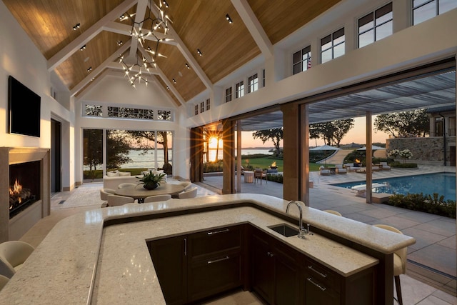 2770 Gale Rd, Woodland, MN 55391 - patio terrace at dusk featuring a warm lit fireplace, area for grilling, a gazebo, an outdoor pool, and a patio
