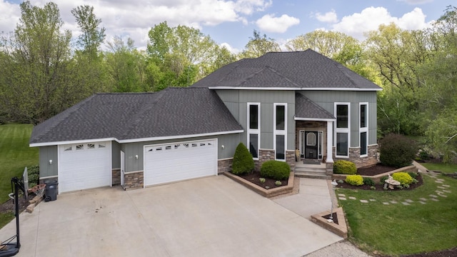 610 Main St, Adams, MN 55909 - view of front of house with stone siding, a shingled roof, an attached garage, concrete driveway, and a front yard