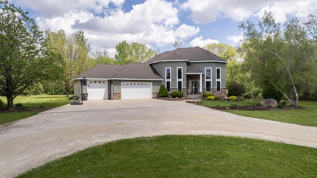 610 Main St, Adams, MN 55909 - view of front of house featuring driveway, a garage, stone siding, and a front yard