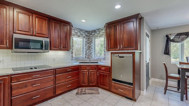 610 Main St, Adams, MN 55909 - kitchen featuring stainless steel appliances, a sink, light tile patterned floors, decorative backsplash, and baseboards