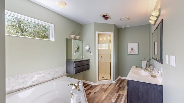 610 Main St, Adams, MN 55909 - full bathroom featuring a stall shower, a garden tub, wood finished floors, vanity, and baseboards