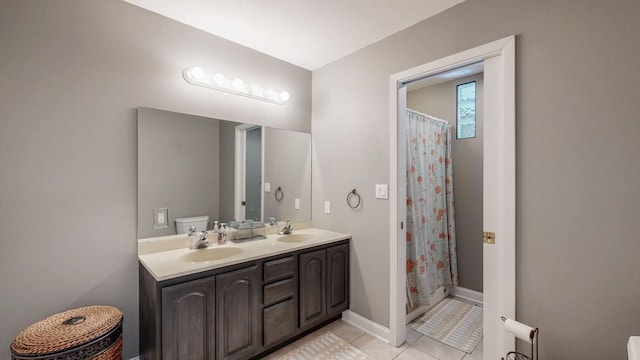 610 Main St, Adams, MN 55909 - bathroom featuring tile patterned flooring, double vanity, toilet, baseboards, and a shower with curtain