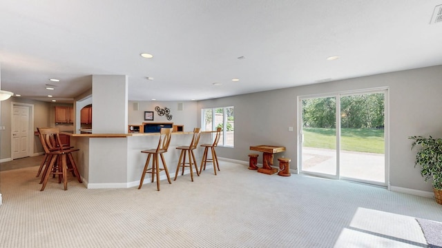 610 Main St, Adams, MN 55909 - kitchen with light carpet, baseboards, recessed lighting, and a kitchen breakfast bar