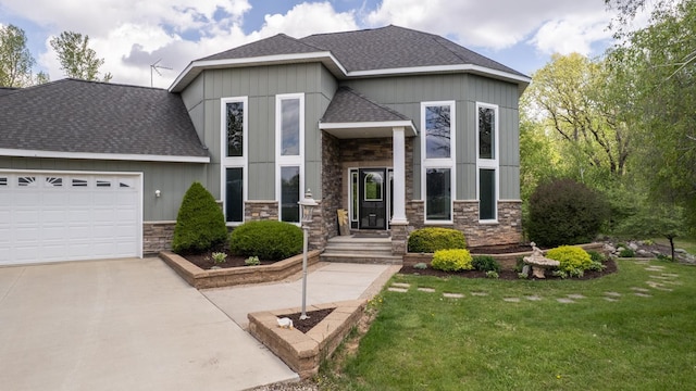 610 Main St, Adams, MN 55909 - view of front facade with stone siding, a shingled roof, a front lawn, driveway, and an attached garage