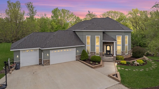 610 Main St, Adams, MN 55909 - view of front of property featuring stone siding, an attached garage, driveway, a shingled roof, and a front yard