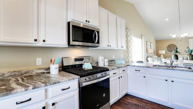 8852 Jorgensen Ave S, Cottage Grove, MN 55016 - kitchen featuring appliances with stainless steel finishes, vaulted ceiling, white cabinetry, a chandelier, and light stone countertops