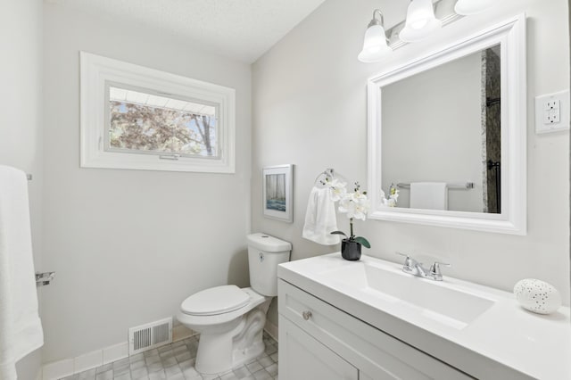 bathroom featuring toilet, vanity, baseboards, and tile patterned flooring