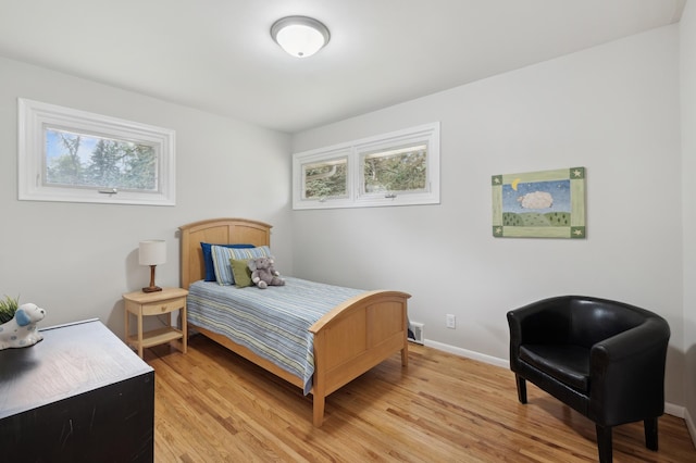 bedroom featuring light wood-style floors and baseboards