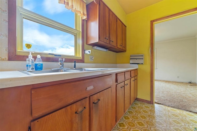2505 Piedmont Ave, Duluth, MN 55811 - kitchen with light colored carpet, a sink, light countertops, and brown cabinets