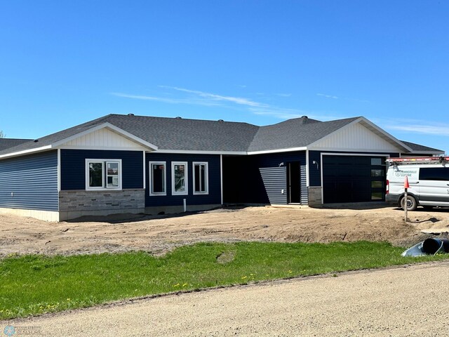 view of front facade with an attached garage and stone siding