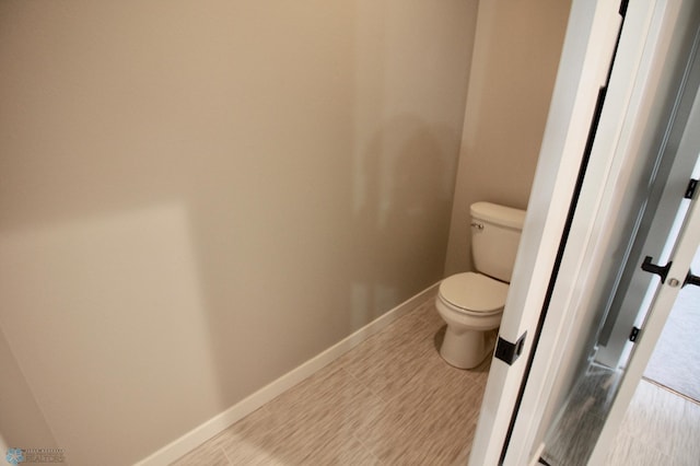 bathroom featuring toilet and baseboards