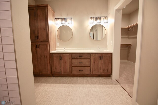 bathroom featuring double vanity and a walk in closet