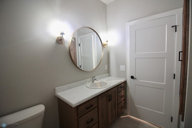 half bath featuring vanity and toilet