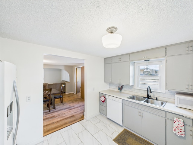 3502 3rd St N, Saint Cloud, MN 56303 - kitchen with white appliances, a sink, light countertops, a textured ceiling, and decorative backsplash