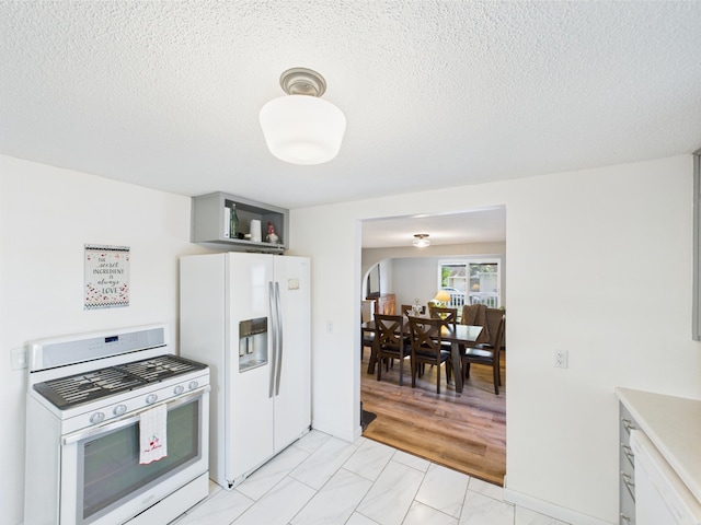 3502 3rd St N, Saint Cloud, MN 56303 - kitchen with white appliances, a textured ceiling, light countertops, and light marble finish floors