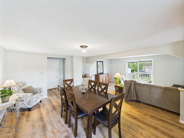 3502 3rd St N, Saint Cloud, MN 56303 - dining space with arched walkways, light wood-style flooring, and a textured ceiling