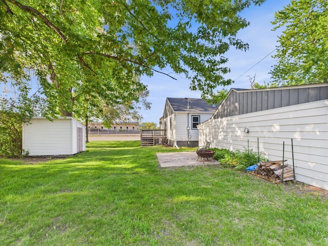 3502 3rd St N, Saint Cloud, MN 56303 - view of green lawn featuring a fire pit, a storage shed, a deck, an outdoor structure, and a patio area