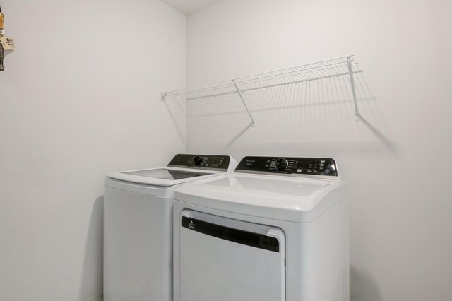 clothes washing area with washer and clothes dryer