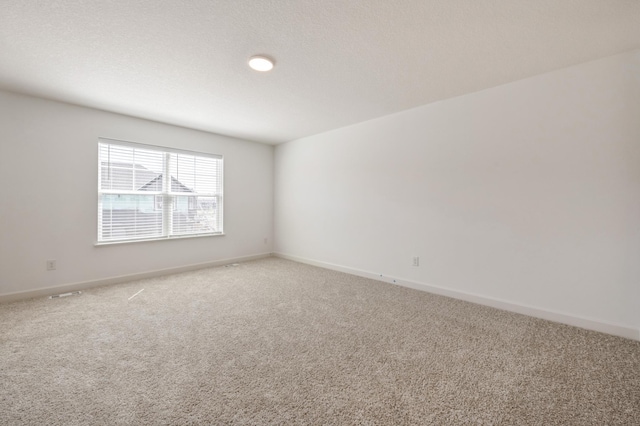 carpeted empty room featuring baseboards