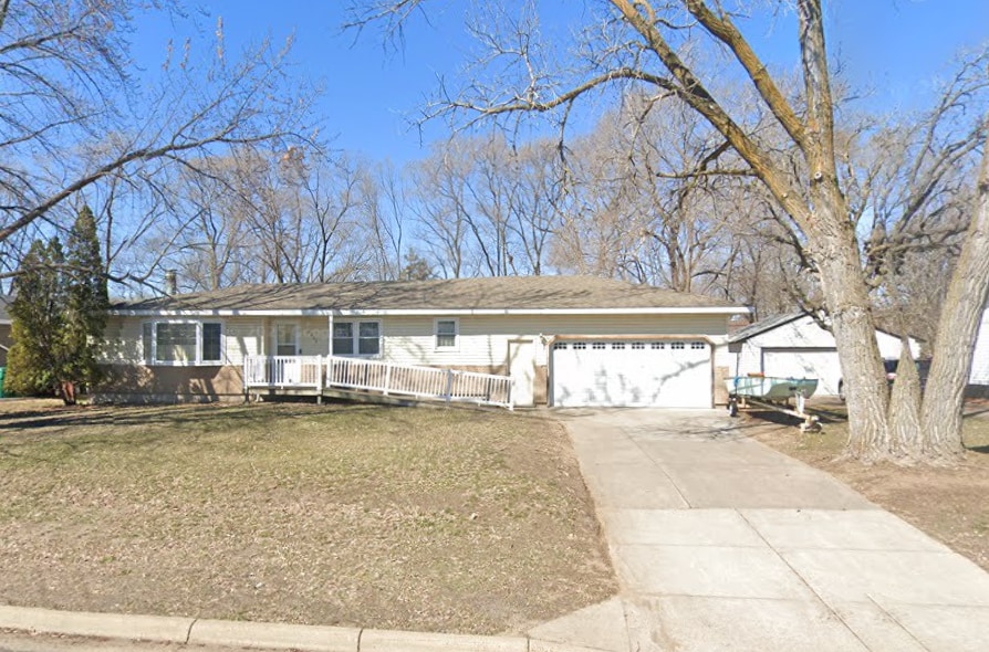 ranch-style house with concrete driveway, a front yard, and covered porch