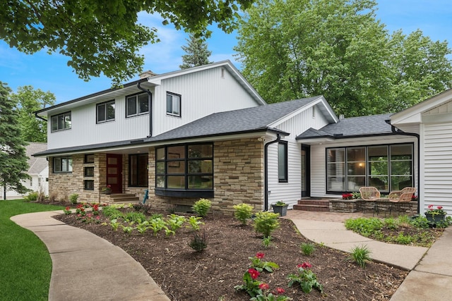 124 Paisley Ln, Golden Valley, MN 55422 - modern inspired farmhouse with stone siding, a porch, and a shingled roof