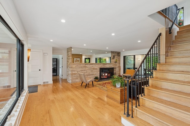 124 Paisley Ln, Golden Valley, MN 55422 - living room featuring a stone fireplace, stairs, wood finished floors, and recessed lighting
