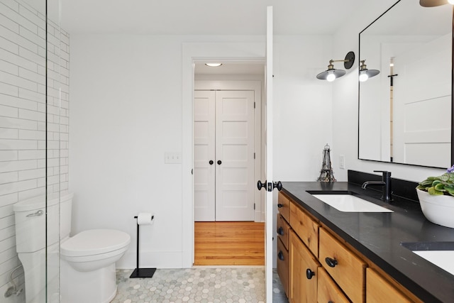 124 Paisley Ln, Golden Valley, MN 55422 - full bathroom featuring double vanity, toilet, tile patterned floors, and baseboards