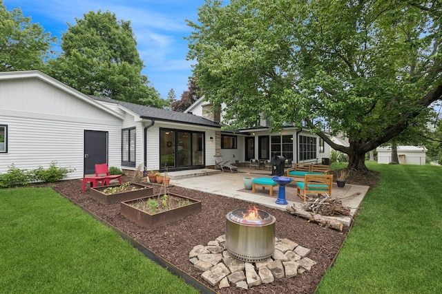 124 Paisley Ln, Golden Valley, MN 55422 - rear view of property featuring a fire pit, a patio, a yard, a sunroom, and a garden
