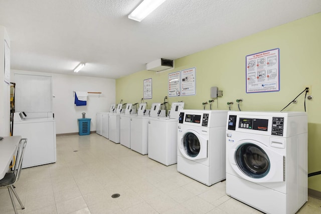 4201 Lakeside Ave N Unit 317, Brooklyn Center, MN 55429 - communal laundry room with washer and clothes dryer, baseboards, and a textured ceiling