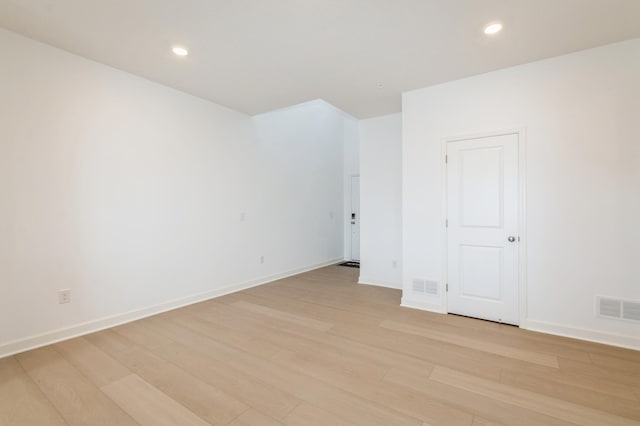 empty room with light wood finished floors, recessed lighting, and baseboards