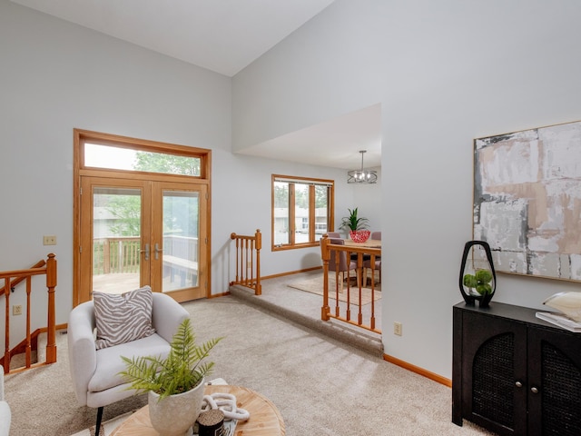 7808 Sunkist Blvd, Brooklyn Park, MN 55444 - living area with french doors, carpet floors, baseboards, high vaulted ceiling, and a chandelier