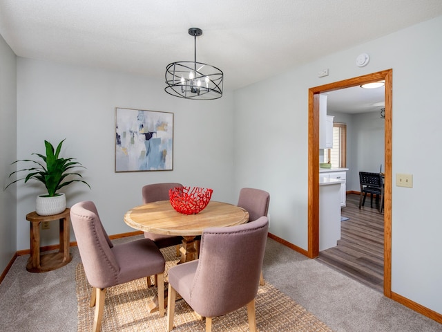 7808 Sunkist Blvd, Brooklyn Park, MN 55444 - dining space featuring a chandelier, baseboards, and light colored carpet