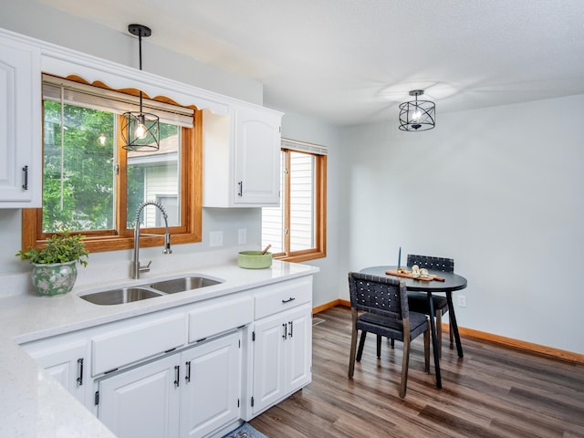 7808 Sunkist Blvd, Brooklyn Park, MN 55444 - kitchen with a sink, light countertops, hanging light fixtures, white cabinetry, and dark wood-style flooring