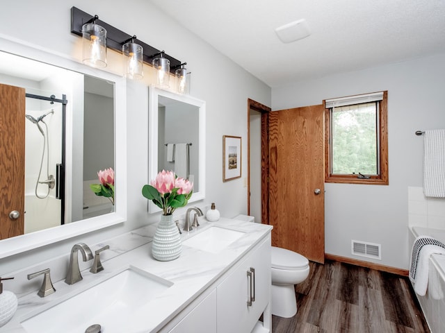 7808 Sunkist Blvd, Brooklyn Park, MN 55444 - full bath featuring wood finished floors, double vanity, a bathtub, toilet, and baseboards
