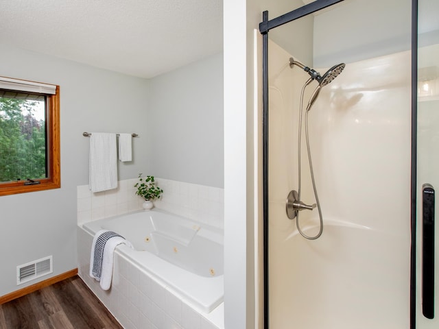 7808 Sunkist Blvd, Brooklyn Park, MN 55444 - full bath featuring wood finished floors, a stall shower, a jetted tub, and baseboards