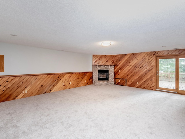 7808 Sunkist Blvd, Brooklyn Park, MN 55444 - unfurnished living room with wooden walls, a fireplace, carpet, a wainscoted wall, and a textured ceiling