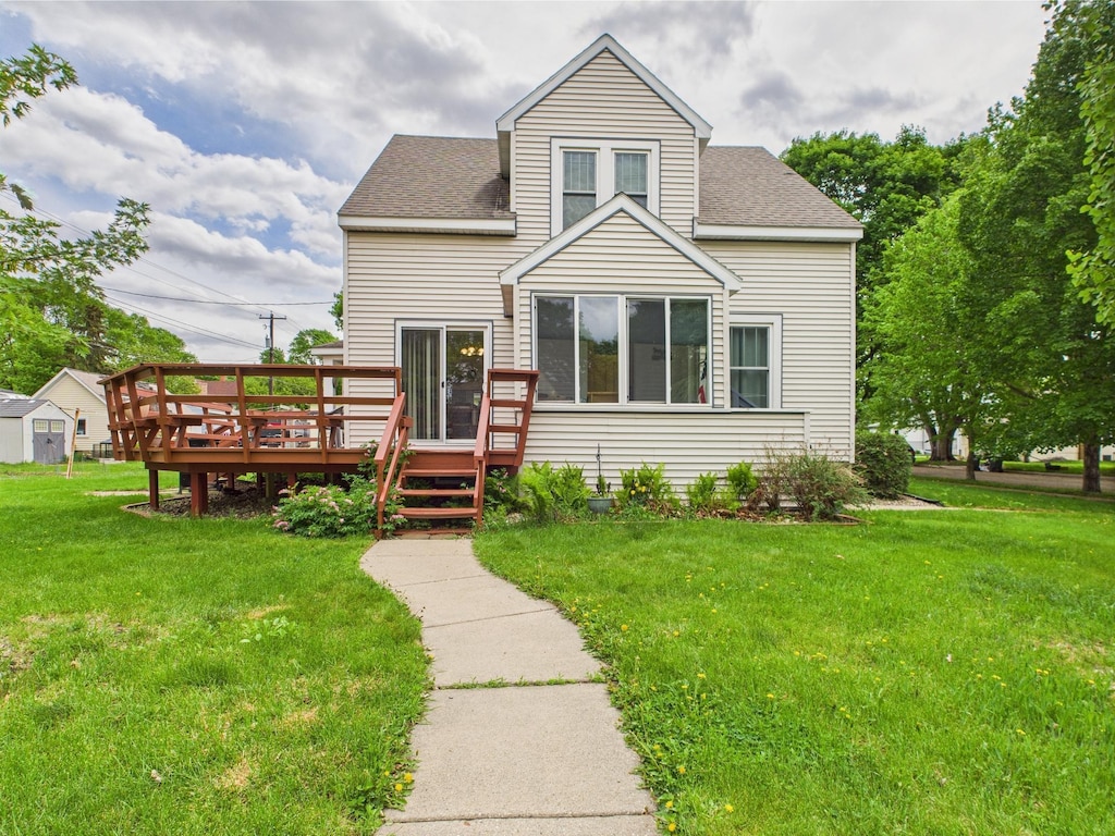 203 2nd Ave SE, Glenwood, MN 56334 - view of front of house featuring a wooden deck, a front yard, and a shingled roof
