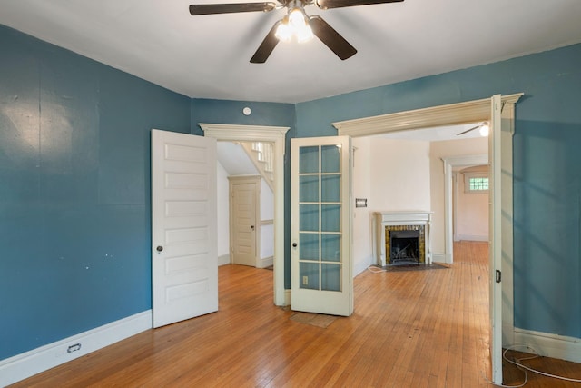 709 7th St SE, Minneapolis, MN 55414 - unfurnished room with a ceiling fan, hardwood / wood-style floors, a fireplace with flush hearth, and baseboards