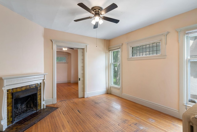 709 7th St SE, Minneapolis, MN 55414 - unfurnished living room with a ceiling fan, hardwood / wood-style flooring, a fireplace with flush hearth, and baseboards