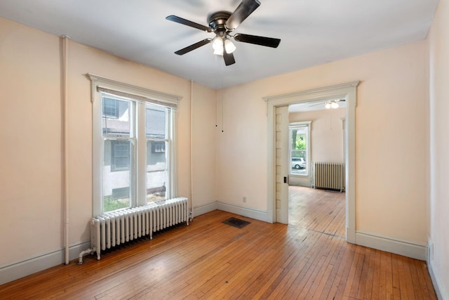 709 7th St SE, Minneapolis, MN 55414 - empty room with radiator heating unit, a ceiling fan, and light wood-style flooring