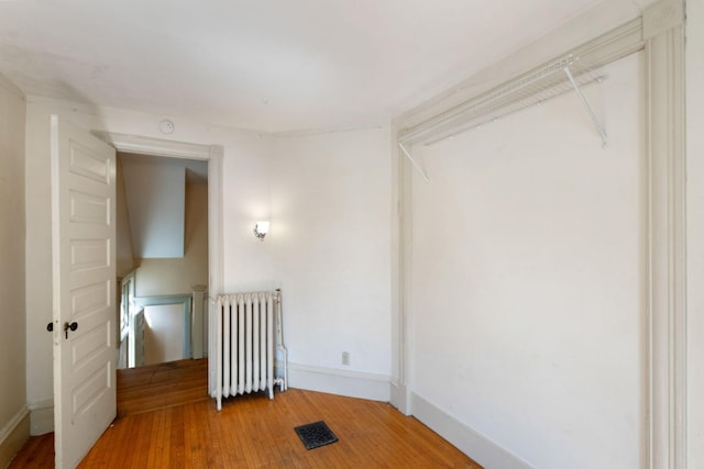709 7th St SE, Minneapolis, MN 55414 - unfurnished room with radiator heating unit, light wood-style flooring, and baseboards