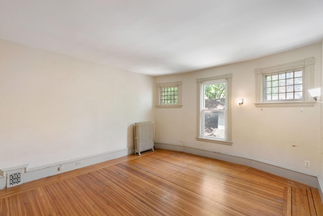 709 7th St SE, Minneapolis, MN 55414 - spare room featuring radiator heating unit, plenty of natural light, baseboards, and wood finished floors