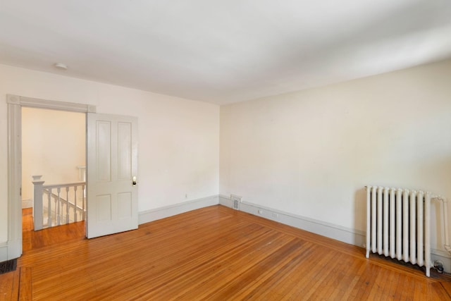 709 7th St SE, Minneapolis, MN 55414 - spare room with radiator, light wood-type flooring, baseboards, and a smoke detector