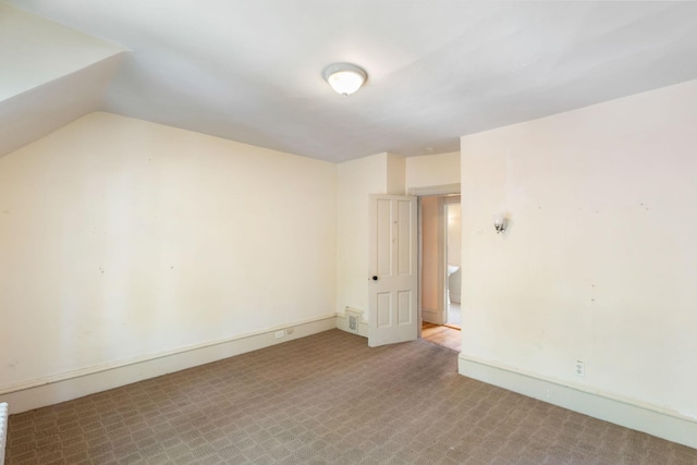 709 7th St SE, Minneapolis, MN 55414 - spare room featuring vaulted ceiling, baseboards, and carpet