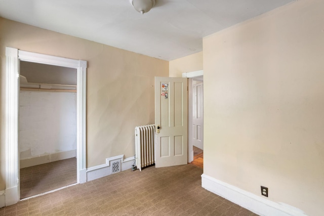 709 7th St SE, Minneapolis, MN 55414 - unfurnished bedroom featuring radiator, carpet flooring, baseboards, and a closet
